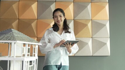 Wall Mural - Beautiful project manager using tablet check house model. Portrait of architect engineer inspect building construction by using data analysis from tablet. Business construction concept. Manipulator.