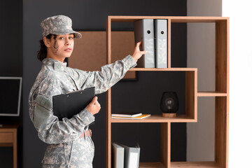 Female African-American soldier taking folder from shelf at headquarters