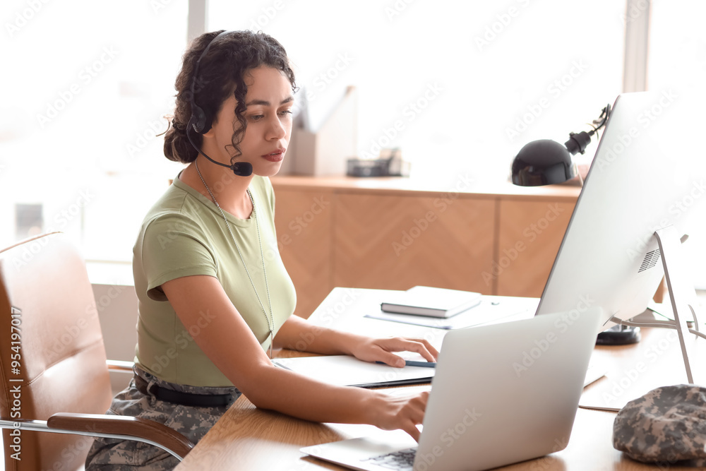Female African-American soldier with headset working at table in headquarters