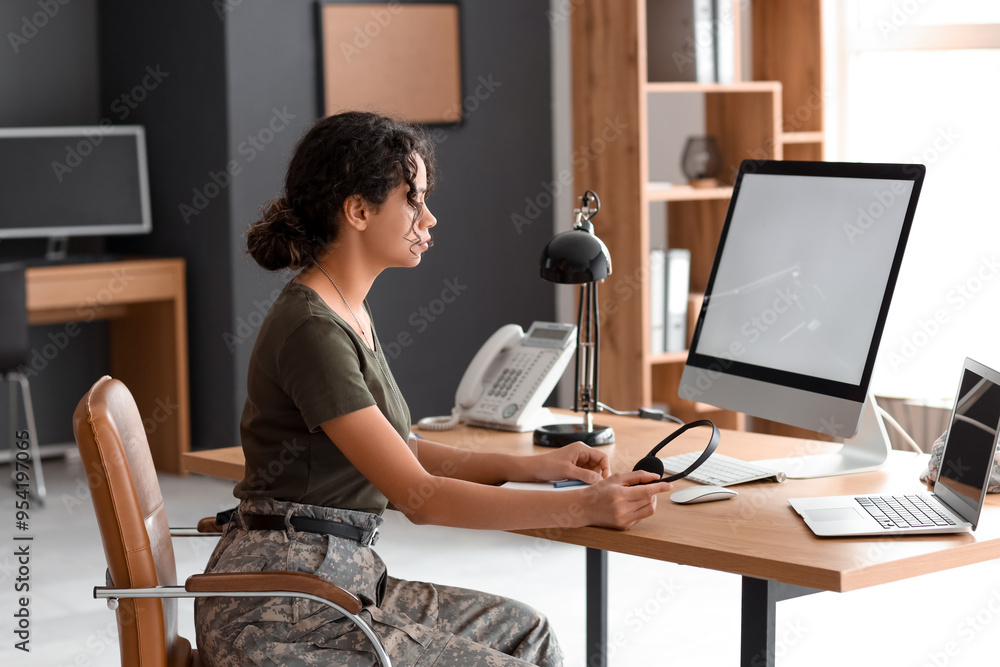 Female African-American soldier sitting at table in headquarters
