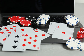 Poster - Online poker. Playing cards, chips, dice and laptop on light grey table