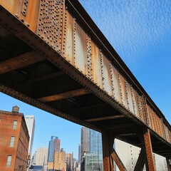 A vintage iron bridge stands tall against a vibrant sky, showcasing urban architecture and rich history in the city landscape.