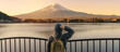 © Jo Panuwat D - Woman tourist with Fuji Mountain at Lake Kawaguchi, happy Traveler sightseeing Mount Fuji in Fujikawaguchiko, Yamanashi, Japan. Landmark for tourists attraction. Japan Travel, Destination and Vacation