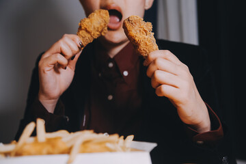 Wall Mural - close up focus woman hand hold fried chicken for eat,girl with fast food concept