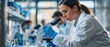 © Nuth - Female scientist in a laboratory looking through a microscope, conducting research and experiments in a modern scientific environment.