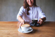 © Farknot Architect - Closeup image of a young woman holding and serving two cups of hot coffee