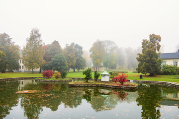 Wall Mural - Pond with a birdhouse in a park at autumn