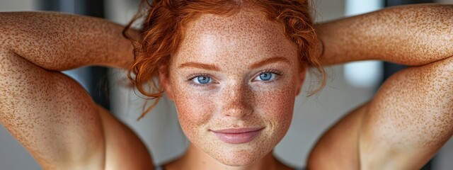 Sticker -  A woman with freckled hair and blue eyes poses for a photo with her hands resting behind her head