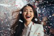 © Surachetsh - Dressed sharply in a business suit, a professional woman lets out an exuberant smile amidst a cascade of confetti, embracing the white hues of celebration.
