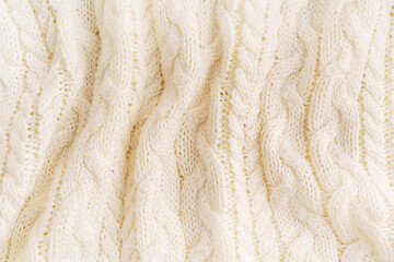 Background of elevated view of fabric of white beige woven cozy warm casual sweater cardigan textile craft knitted from soft comfortable merino or wool yarn with stripes used at cold winter season