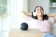 © Antonioguillem - Happy woman listening music from smart speaker