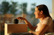 © Antonioguillem - Happy woman using smart speaker at sunset