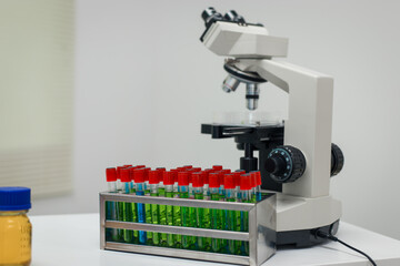 A modern laboratory scene showcasing scientists, both male , in lab coats, analyzing samples using microscopes and computers.