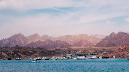 cruise boats near the rocky shore