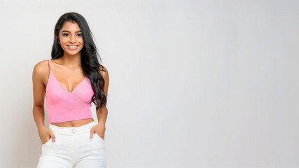 Wall Mural - A portrait of a South Asian woman wearing a pink tube top and white skinny pants.