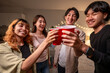 © Kawee - Group of Asian friends having evening party in living room at home.