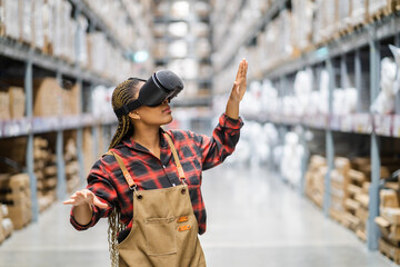 Wall Mural - Young africn woman wearing virtual reality (VR) goggles stands in middle of warehouse with shelves stocked, traditional workwear and modern technology, technology logistics in industrial and warehouse