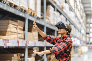 Wall Mural - Young africn woman wearing virtual reality (VR) goggles stands in middle of warehouse with shelves stocked, traditional workwear and modern technology, technology logistics in industrial and warehouse