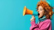 © angel_nt - A lively young woman with a playful expression shouts into a bright orange megaphone while wearing a colorful sweater and scarf, all set against a vivid blue backdrop