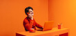 © Jacob Lund - Business consultant in a vibrant orange monochromatic space, handling a client call and using a laptop