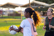 © Austockphoto - aboriginal girl catching netball with Caucasian umpire or coach in background