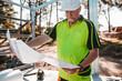 © Austockphoto - A contractor holding and looking at the construction blueprint.