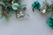 © RooM The Agency - Overhead view of two wrapped Christmas gifts, fir branches, Christmas baubles, ornaments and decorations on a grey background