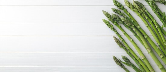 Poster - Creative Scandinavian style flat lay top view mockup featuring fresh green asparagus on a white wooden table background with copy space