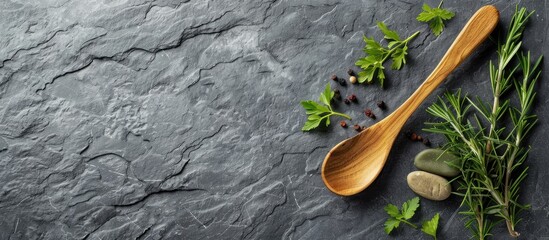 Fototapete - herbs and a wooden spoon on a gray slate background. with copy space image. Place for adding text or design