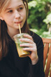© ADDICTIVE STOCK - Teenage girl sipping on a summer iced matcha outdoors