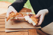 © ADDICTIVE STOCK - Close-up of hands breaking a croissant over a wooden table