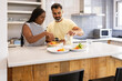 © ADDICTIVE STOCK - Interracial couple cooking together in a modern kitchen