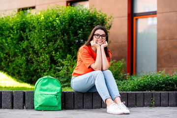 Sticker - Full size photo of positive teen adorable cheerful woman sit student dreamy charming wear red outfit walk park sunny spring weather outside