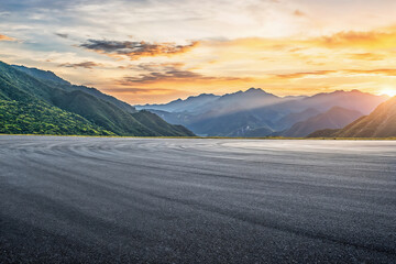 Empty asphalt road surface and mountain scenery at sunset. High quality photo