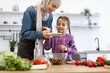 © sofiko14 - Muslim mother and daughter take photo of healthy salad for social networks, media, blog. They enjoy quality time together cooking fresh vegetables promoting healthy lifestyle