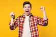 © ViDi Studio - Young fun smiling happy man he wears red checkered shirt casual clothes hold car key fob keyless system do winner gesture isolated on plain yellow orange background studio portrait. Lifestyle concept.