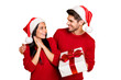 © deagreez - Portrait of handsome man in xmas hat give package to his impressed wife wear red pullover isolated over yellow background