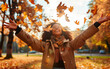 © Kseniya - Casual joyful woman having fun throwing leaves in autumn at city park