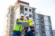 © NVB Stocker - Architect and contractor working on building in construction site. Two Professional Architects Engineer Working on Personal laptop computer at house construction site