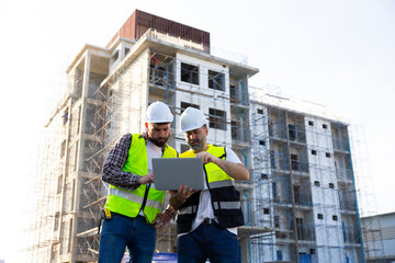 Architect and contractor working on building in construction site. Two Professional Architects Engineer Working on Personal laptop computer at house construction site