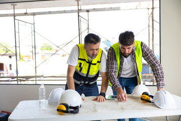 Wall Mural - blueprint. Builders and architect looking at plans. employees in construction industry