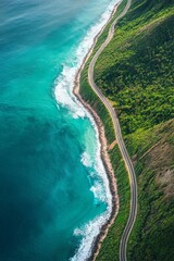 Wall Mural - An aerial view of a winding coastal road, with turquoise waves crashing against the shore and the contrast between land and sea sharply defined. 