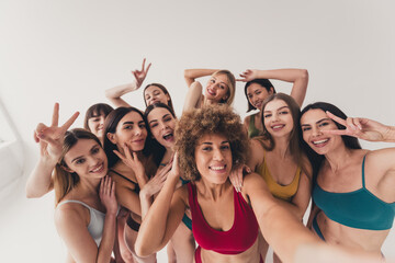 Wall Mural - Studio no retouch photo tender funny ladies dressed lingerie recording vlog showing v-sign enjoying self acceptance isolated beige color wall background