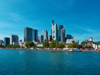 the skyline in frankfurt am main on a beautiful cloudless day with the river in the foreground