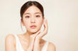 © KayKai - A woman with a white tank top and brown hair is posing for a picture