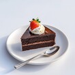 © Going Place - A slice of chocolate cake with a dollop of whipped cream and a strawberry on top, placed on a white plate with a spoon beside it