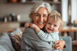 © volga - Smiling grandmother embracing toddler at home