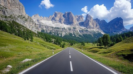 A scenic view of an empty road cutting through Venegia Valley, with towering dolomite mountains in the distance.