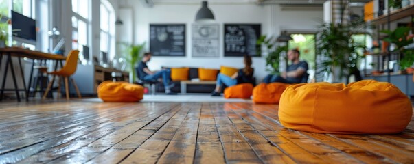 Wall Mural - A modern, casual open office space decorated with orange bean bags, where professionals are engaged in discussion and collaboration