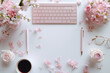 © Sunshine - Top view keyboard and pen are on a table with pink flowers with copy space. Concept of creativity and productivity